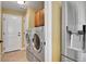 Functional laundry room featuring modern washer and dryer units, with adjacent access to the kitchen at 9218 Viaggio Way, Highlands Ranch, CO 80126