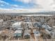 Expansive aerial view of a residential neighborhood, lake, and distant mountains against a cloudy sky at 4440 W Hayward Pl, Denver, CO 80212