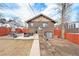 Brick home backyard featuring concrete patio with outdoor furniture and red fence at 4440 W Hayward Pl, Denver, CO 80212