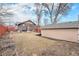 Backyard featuring a brick home, patio with outdoor seating, shed, and a red fence at 4440 W Hayward Pl, Denver, CO 80212