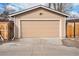 Tan two-car garage with panel door and a wood fence, located at the back of the property at 4440 W Hayward Pl, Denver, CO 80212