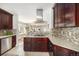 Open-concept kitchen boasts a modern range hood, sleek countertops, and seamlessly connects to the living area at 4440 W Hayward Pl, Denver, CO 80212