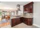 Well-lit kitchen with dark wood cabinetry, stainless steel range hood, and an inviting view into the dining area at 4440 W Hayward Pl, Denver, CO 80212