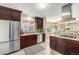 Bright, open kitchen featuring stainless steel appliances, dark wood cabinets, and views to the living space at 4440 W Hayward Pl, Denver, CO 80212