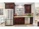 Charming kitchen featuring stainless steel appliances, dark wood cabinets, and a stylish tile backsplash at 4440 W Hayward Pl, Denver, CO 80212