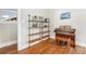 Bright living room showcasing stylish shelving, a piano, and gleaming hardwood floors at 4440 W Hayward Pl, Denver, CO 80212