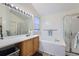 Relaxing bathroom with a soaking tub, white tile, and bright vanity lighting at 2275 S Kenton St, Aurora, CO 80014