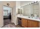 Well-lit bathroom featuring a large mirror, wood cabinets, and tile flooring at 2275 S Kenton St, Aurora, CO 80014