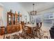 Cozy dining room with a wooden table set for six, chandelier, china cabinet, rug, and plenty of natural light at 2275 S Kenton St, Aurora, CO 80014