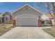 A two car garage with brick pillars on a home with a driveway and an ADT security sign in the front yard at 2275 S Kenton St, Aurora, CO 80014
