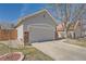 Two car garage with an ADT security sign in the yard and a small garden with rocks and greenery at 2275 S Kenton St, Aurora, CO 80014