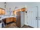 Functional kitchen featuring stainless steel appliances, oak cabinets, tile flooring, and a door to the outside at 2275 S Kenton St, Aurora, CO 80014