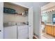 Convenient laundry room with washer, dryer, and storage shelving, adjacent to bathroom at 2275 S Kenton St, Aurora, CO 80014