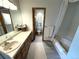 Bathroom with an extended countertop, tub, and a separate toilet room at 3262 S Salida Way, Aurora, CO 80013
