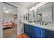 Nicely remodeled bathroom featuring double vanity with blue cabinets and modern fixtures at 5746 Aspen Creek Dr, Broomfield, CO 80020