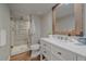 Bathroom with quartz countertops, a white vanity, a walk-in shower, and wood-look tile flooring at 5746 Aspen Creek Dr, Broomfield, CO 80020