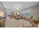 Large living room with a decorative rug, large windows, and an open floor plan flowing into the kitchen at 5746 Aspen Creek Dr, Broomfield, CO 80020