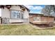 Exterior of home with a stone foundation, a wooden deck, and well maintained lawn at 16500 Crosby Dr, Broomfield, CO 80023