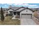 Charming stucco home featuring a two-car garage and stone accents on the front facade at 16500 Crosby Dr, Broomfield, CO 80023