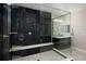 Contemporary bathroom showcasing a glass-enclosed shower with sleek, dark tile, complemented by stylish fixtures and lighting at 6123 Chester Way, Denver, CO 80238