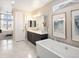 Elegant bathroom featuring a soaking tub, dual vanity, and picture frame mirror, exuding luxury and sophistication at 6123 Chester Way, Denver, CO 80238