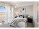 Serene bedroom featuring a plush bed, stylish lighting, and large windows with scenic views and soft, sheer curtains at 6123 Chester Way, Denver, CO 80238