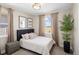 Cozy bedroom with neutral colors, upholstered headboard and a large window with neighborhood views at 6123 Chester Way, Denver, CO 80238