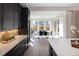 Bright dining area featuring dark cabinets, white countertops, and an island with a sink that overlooks a spacious dining room at 6123 Chester Way, Denver, CO 80238