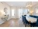 Bright dining room featuring a modern chandelier, large windows, and elegant decor at 6123 Chester Way, Denver, CO 80238