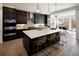 Beautiful kitchen with dark cabinets, white countertops, a large island with seating, and stainless steel appliances at 6123 Chester Way, Denver, CO 80238