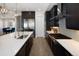 Open kitchen showcases dark cabinetry, stainless steel appliances, and a large island with a breakfast bar overlooking the dining area at 6123 Chester Way, Denver, CO 80238
