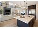 Spacious living area showcases a kitchen with a large island, and dark cabinets overlooking a bright living room with fireplace at 6123 Chester Way, Denver, CO 80238