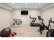 Basement workout area with a treadmill, exercise bike and storage shelves at 6123 Chester Way, Denver, CO 80238