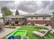 Spacious backyard with an outdoor seating area, a lounge area, an inflatable pool, and a well-manicured lawn at 6346 Fenton St, Arvada, CO 80003