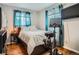 Bedroom with wood floors, a queen bed, and a mounted TV, creating a comfortable and functional space at 6346 Fenton St, Arvada, CO 80003