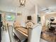 Elegant dining room featuring tufted chairs, a modern light fixture, and seamless transition to the living area at 6346 Fenton St, Arvada, CO 80003