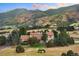 House nestled in a mountainous landscape with a tractor in the yard at 12768 Grizzly Dr, Littleton, CO 80127