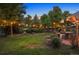 Landscaped backyard with string lights, patio, and pond at night at 12768 Grizzly Dr, Littleton, CO 80127