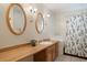 Bathroom with double vanity, oval mirrors and a shower/tub combo at 12768 Grizzly Dr, Littleton, CO 80127