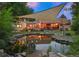 Serene backyard pond with illuminated fountain and patio at 12768 Grizzly Dr, Littleton, CO 80127