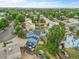 Aerial view of a blue home with mature trees, fenced backyard, and lush surroundings at 1922 Danube Way, Aurora, CO 80011