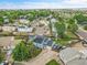 Aerial view of a blue home with solar panels in a neighborhood with mature trees and a fenced yard at 1922 Danube Way, Aurora, CO 80011