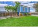 Expansive backyard featuring lush green grass, wood fence, mature tree and well manicured landscaping at 1922 Danube Way, Aurora, CO 80011