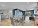 Bright dining area with glass table and modern chairs, opens to a living area and patio, with ample natural light at 1922 Danube Way, Aurora, CO 80011