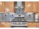 A modern kitchen features stainless steel appliances, wooden cabinets, and a tiled backsplash at 1922 Danube Way, Aurora, CO 80011