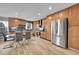 Modern kitchen with stainless steel appliances, wood cabinets, dining table, and sleek tile backsplash at 1922 Danube Way, Aurora, CO 80011
