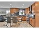 Modern kitchen featuring stainless steel appliances, wood cabinets, an island, and sleek tile backsplash at 1922 Danube Way, Aurora, CO 80011