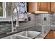 Kitchen sink with stainless steel faucet, granite countertops, and backsplash with window view at 1922 Danube Way, Aurora, CO 80011