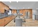 Bright kitchen with stainless steel appliances, wood cabinets, granite countertops, and tile backsplash at 1922 Danube Way, Aurora, CO 80011