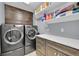 Updated laundry room featuring front load washer/dryer and built-in storage at 1922 Danube Way, Aurora, CO 80011